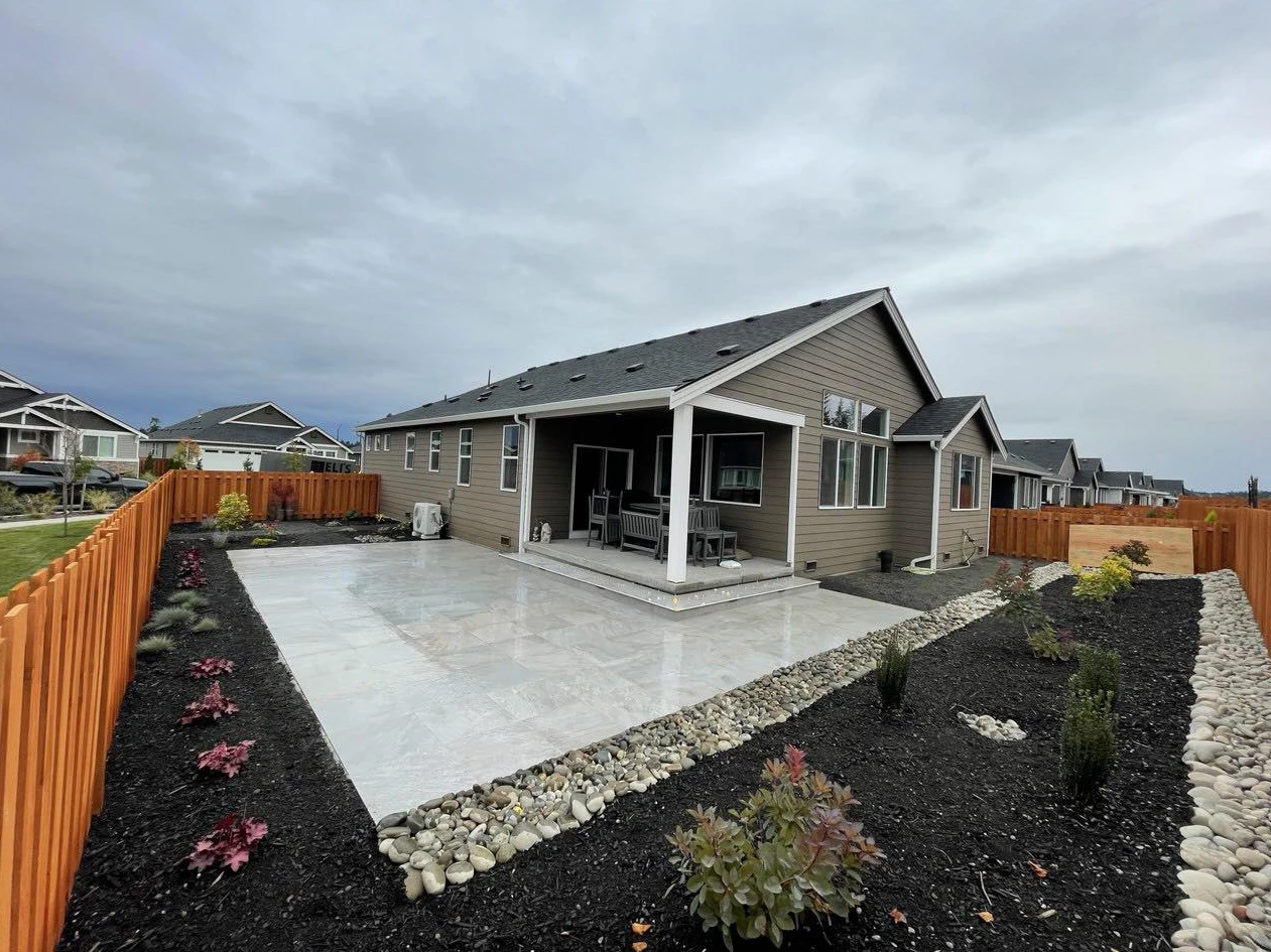 The same backyard after the completed paver patio and landscaping transformation.