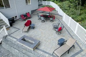 Aerial view of a paved outdoor living area with seating and a fire feature.