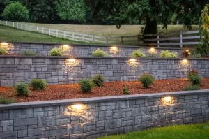 Illuminated retaining walls across a landscaped sloping garden.