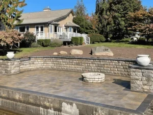 Finished backyard hardscape with curved paving and retaining walls.