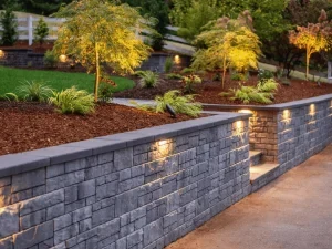 Illuminated retaining walls lining a landscaped garden.