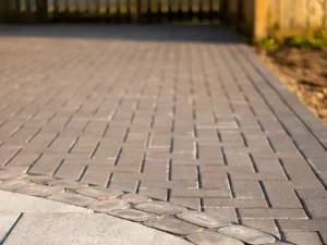 Finished interlocking paver surface along a landscaped edge.
