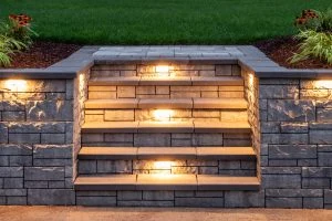 Illuminated block steps built into a landscaped retaining wall.