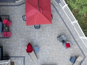 Aerial view of a paved backyard entertaining area with seating.