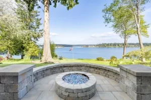 Paver patio and fire pit overlooking a lake.